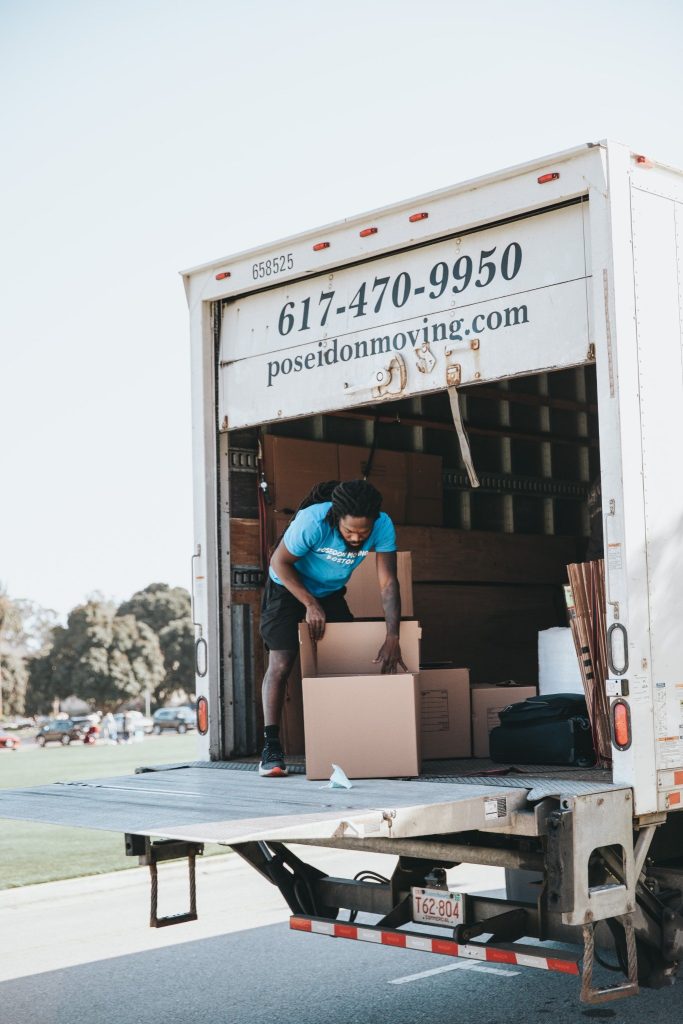 Poseidon Moving truck with a mover unloading boxes during a Boston to New York move.