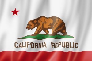 California Republic flag with a brown bear walking on grass and a red star above.