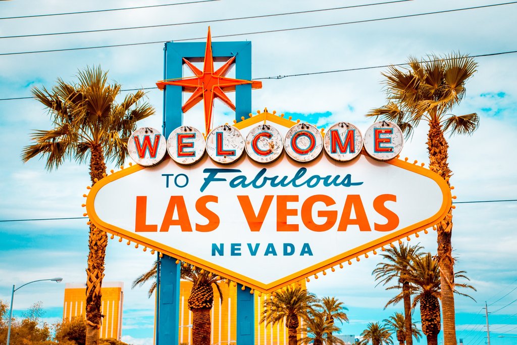 Welcome to Fabulous Las Vegas sign in Las Vegas, Nevada, with palm trees and a bright sky in the background.