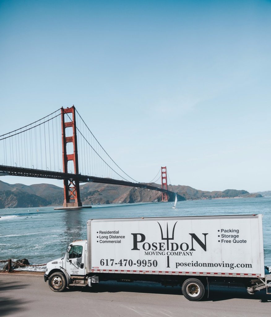 Poseidon Moving truck parked in front of the Golden Gate Bridge, representing San Francisco movers.