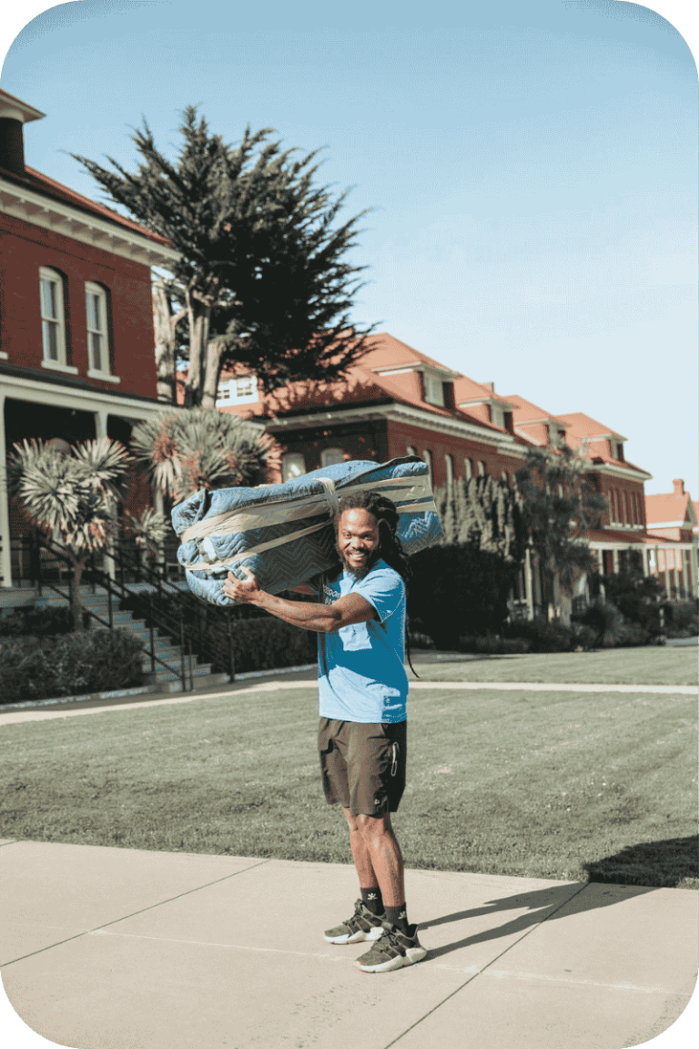 Smiling Poseidon Moving foreman carrying wrapped furniture