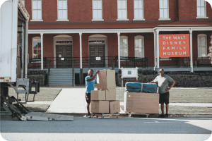 Poseidon Moving Company team offloading furniture and boxes from a branded moving truck at customer destination