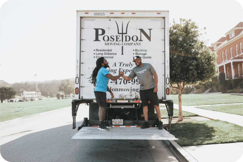 Poseidon Moving crew shaking hands on truck liftgate after completing a successful move.