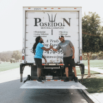 Poseidon Moving crew shaking hands on truck liftgate after completing a successful move.
