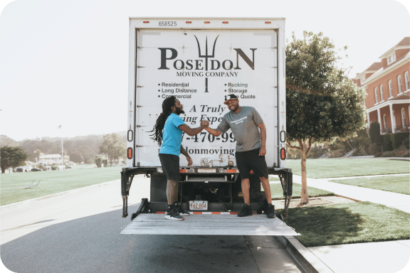 Poseidon Moving crew shaking hands on truck liftgate after completing a successful move.