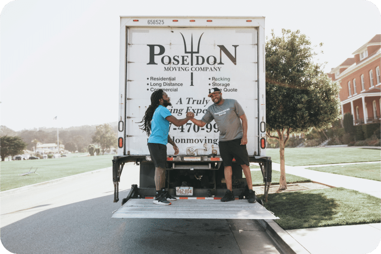 Poseidon Moving crew shaking hands on truck liftgate after completing a successful move.