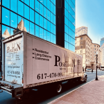 Poseidon Moving Company truck parked in downtown Boston near historic buildings and offices.