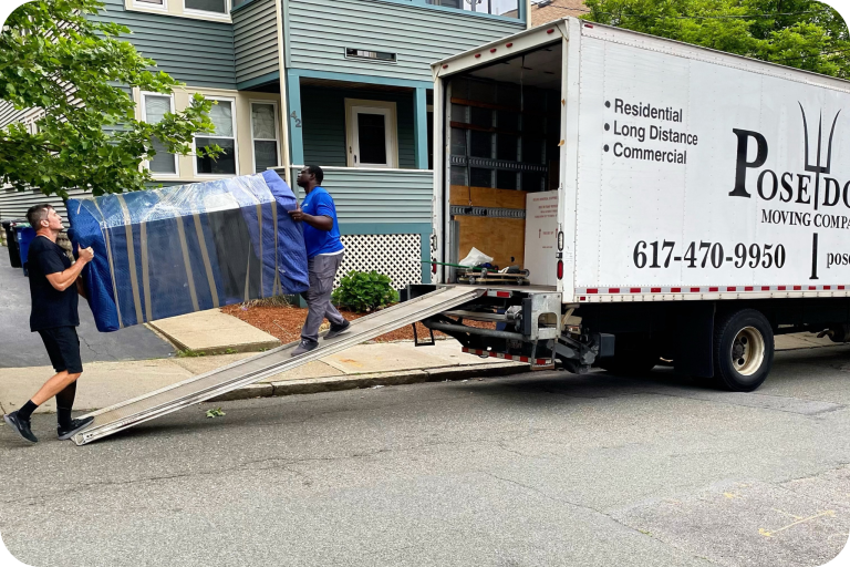 Poseidon Moving team loading a wrapped furniture piece onto a truck using a ramp.