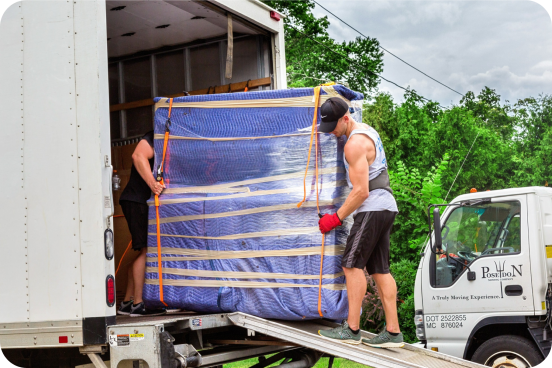 Two professional movers loading a shrink-wrapped piece of furniture into a Poseidon Moving truck using a ramp