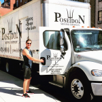 Poseidon Moving foreman standing beside branded moving truck on a city sidewalk