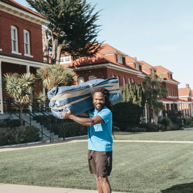 Poseidon mover carrying a blanket-wrapped item during a move