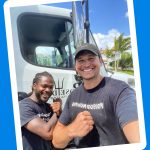 Two Poseidon Moving Company crew members in front of a moving truck