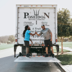 Two Poseidon Moving Company crew members at the back of a moving truck
