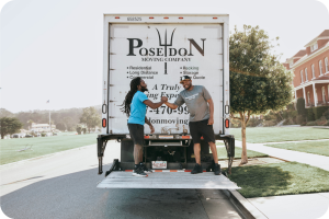 Two Poseidon Moving Company crew members at the back of a moving truck